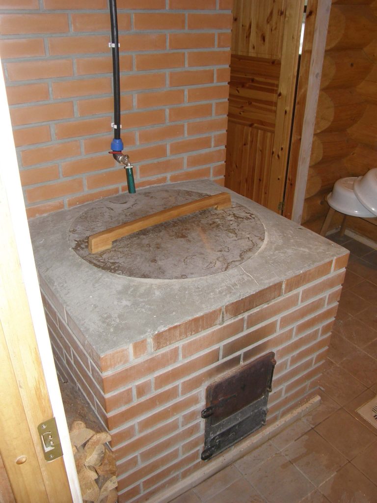 Log sauna with a furnace with a cauldron